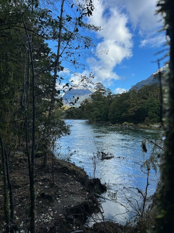 Perfect mountain reflections in calm river on the Routeburn Track New Zealand