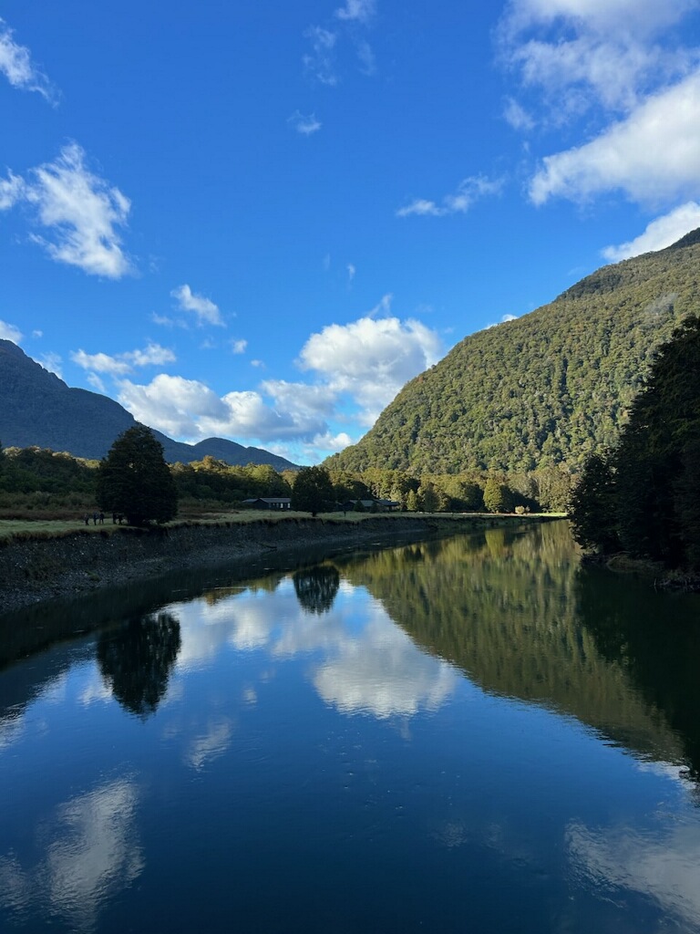 Helicopter departing from beside the Routeburn Track with snow capped mountains New Zealand