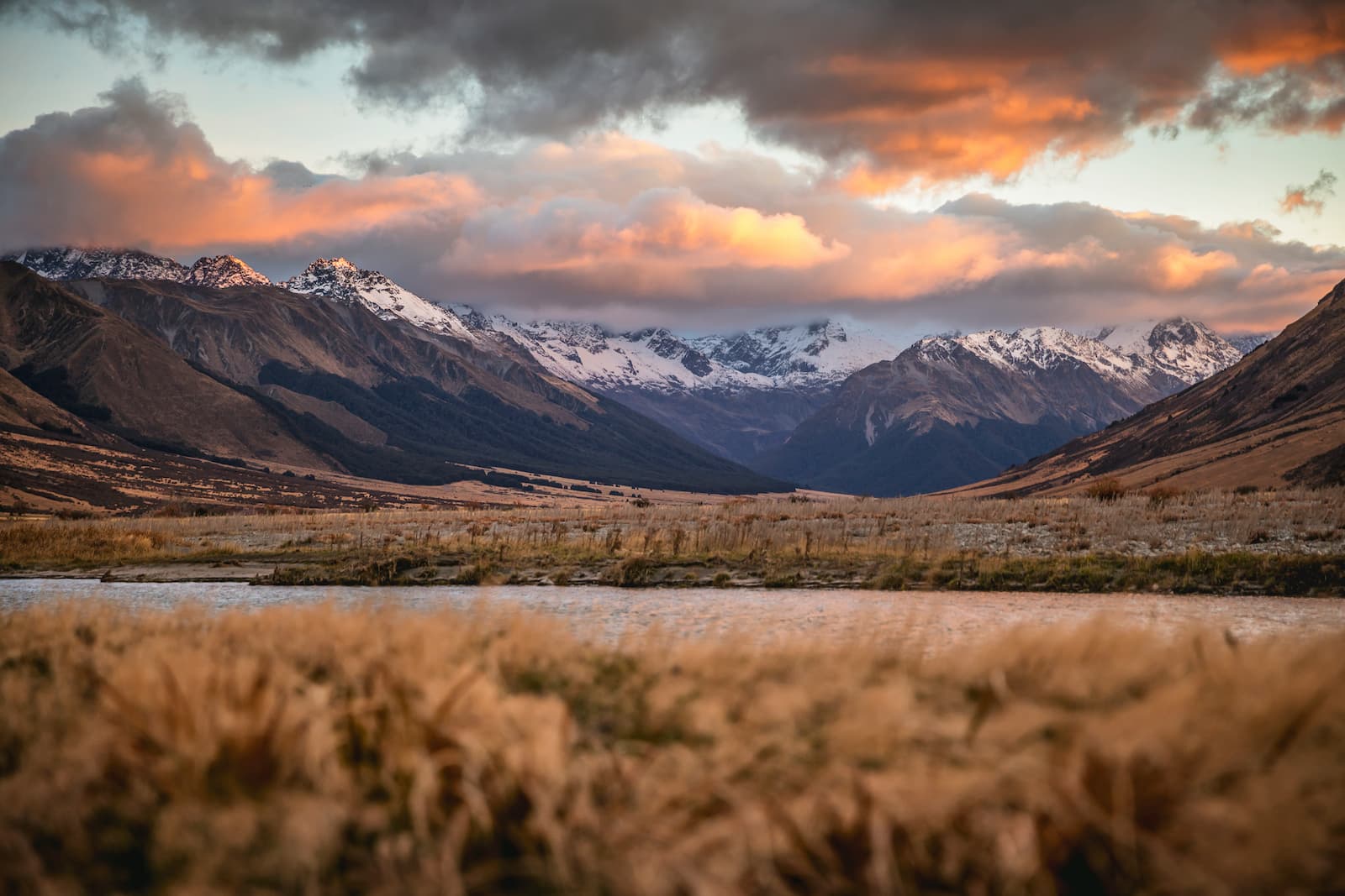 Lindis Pass sunset with snow-capped mountains and tussock Canterbury